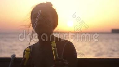 在美丽的夕阳下，快乐的黑发女人在游轮上吹肥皂泡。 慢动作。 3840x2160